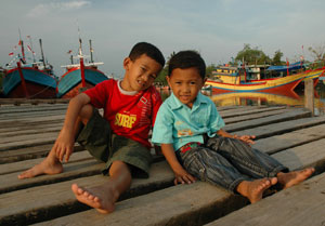 two boys sitting on dock