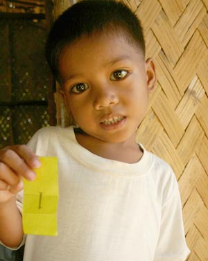 boy holding yellow paper with the number one