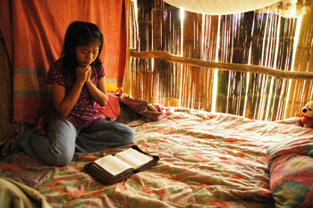 girl reading her bible and praying