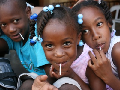 three Dominican children with lollipops