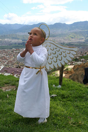 small child dressed as an angel praying