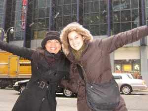 two women in coats standing on city sidewalk