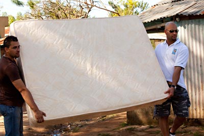 two men carrying a mattress