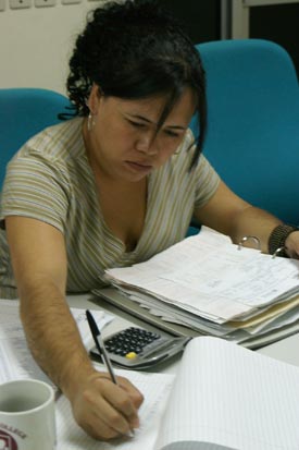 A woman at a desk writing on a piece of paper