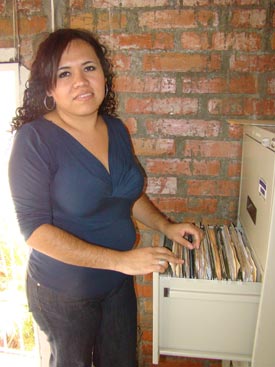 A woman standing by an open file cabinet