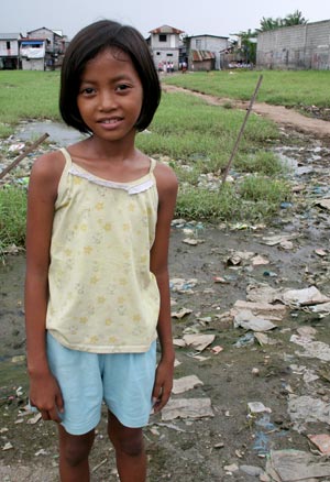 smiling girl in yellow shirt and blue shorts