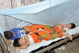 three children sleeping in same bed