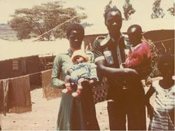 man holding a child, woman holding a baby and another child standing