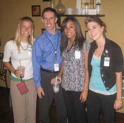 three women and a man standing together for photo