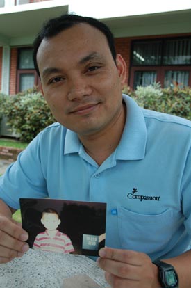 young man holding a photo of a child