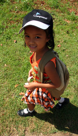 Young girl walking wearing a Compassion hat.