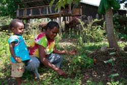 woman weeding with young boy