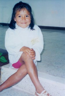 A smiling girl sitting with her legs crossed
