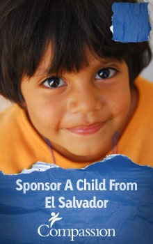 smiling child in orange shirt on Compassion banner