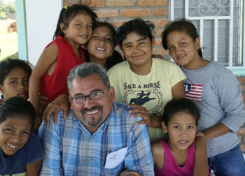 man surrounded by smiling children