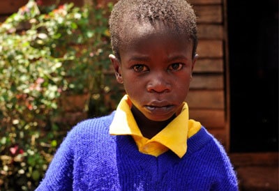 young boy wearing yellow shirt and blue sweater