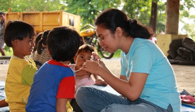 girl working with smaller children's hands