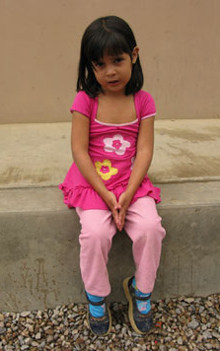 girl dressed in pink siting on step
