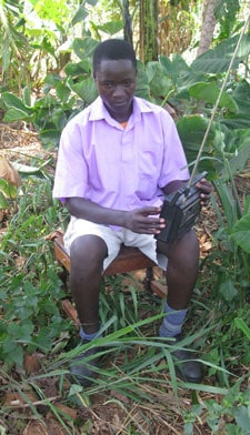 man sitting on a stool listening to a radio