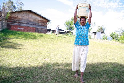 woman carrying pail of water on head