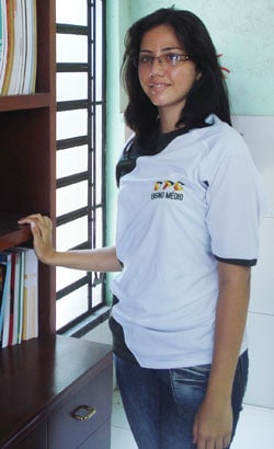 Young lady standing in front of a bookcase.