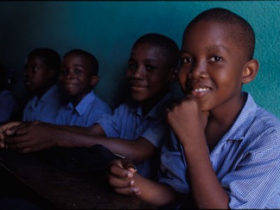 four smiling boys wearing blue shirts