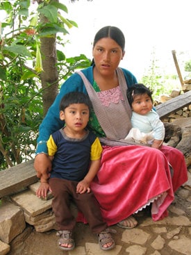 young woman sitting with two children