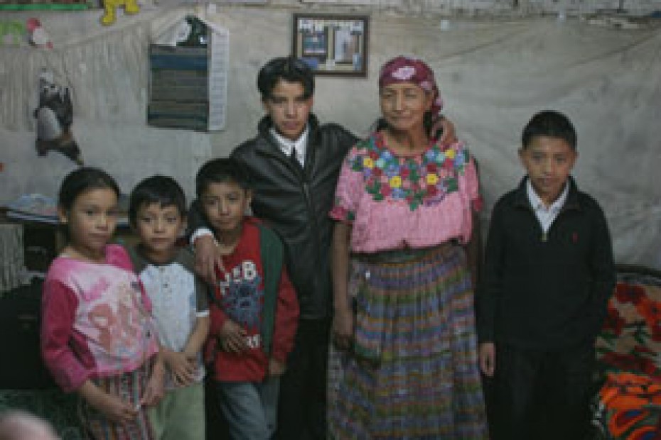Young man with his 4 younger siblings and grandmother standing in their home