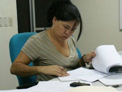woman looking through paperwork at desk