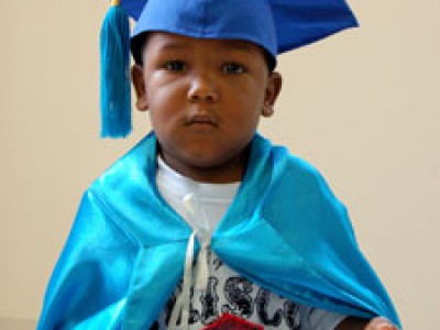 Young child in graduation cap and gown.