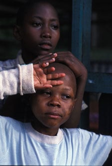 A young child holds hand to head