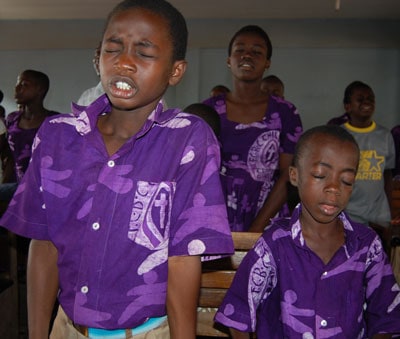 boys and girls praying with their eyes closed