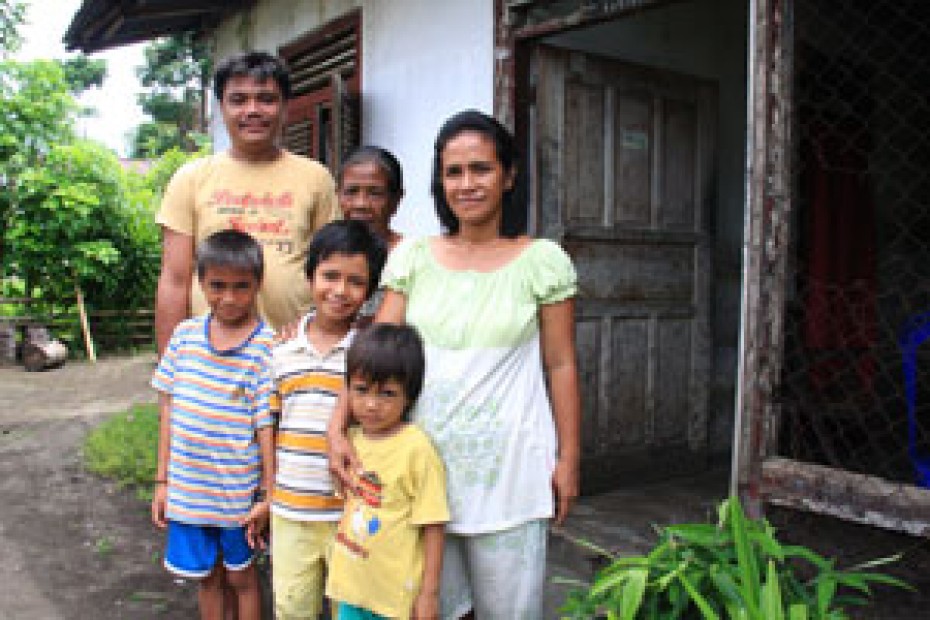 family standing outside their home in Indonesia