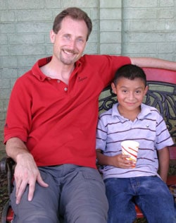 man sitting on bench with boy in Guatemala