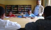 children around table in classroom reading