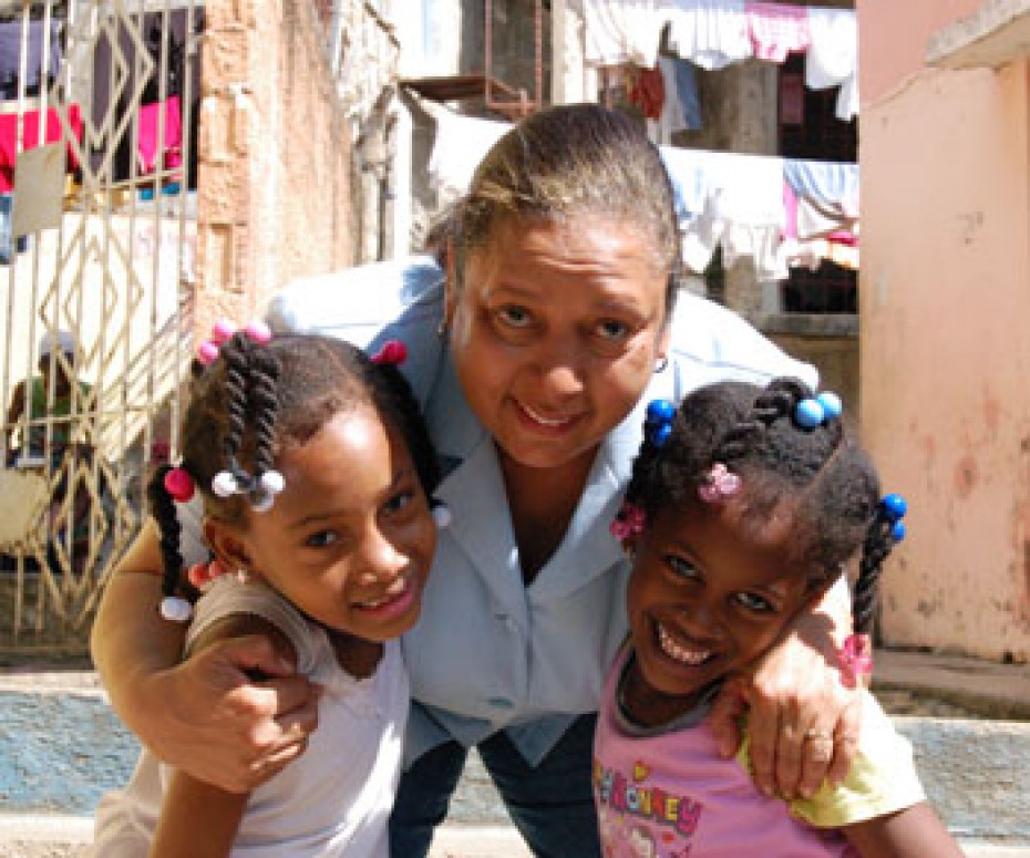 woman stooping down to give girls a hug