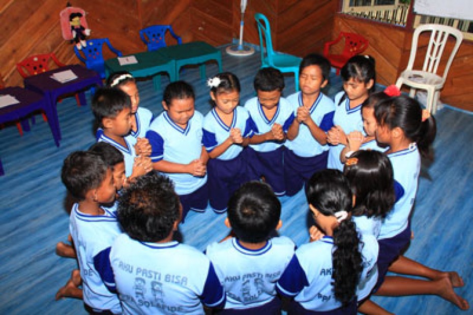 group of kneeling children praying