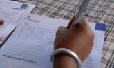 a hand holding a pen writing a Compassion letter