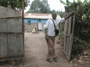 young man standing with hand on a gate