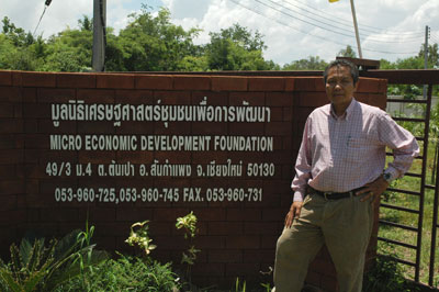 Thai man standing in front of business sign