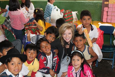 girl with blonde hair surrounded by a group of smiling kids