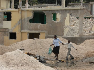 two children walking past dirt hills