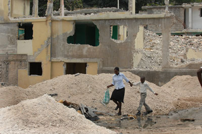 woman and child walking through rubble in Haiti