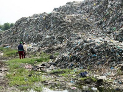 two people walking in garbage dump