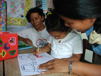 child being helped with a coloring page