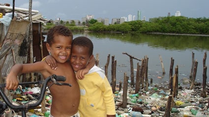 two boys side hugging with a river behind them