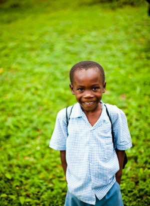 young boy standing on green grass