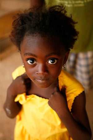 young girl looking up wearing yellow dress