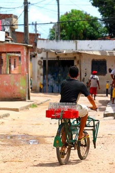 man riding bicycle carrying soda bottles