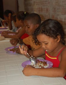 children sitting at table eating